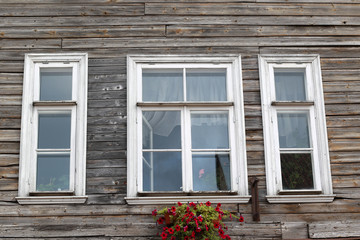 Fototapeta na wymiar three white wooden window frames and flower box