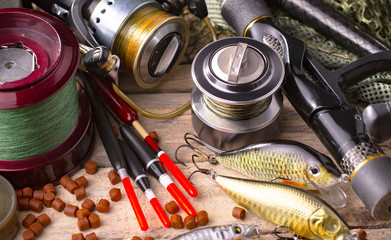 Fishing rods and spinnings in the composition with accessories for fishing on the old background on...
