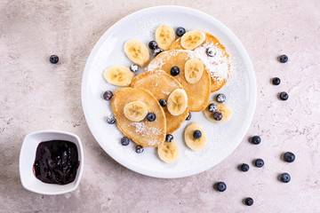 pancakes with banana and blueberries on a white plate, tasty and beautiful