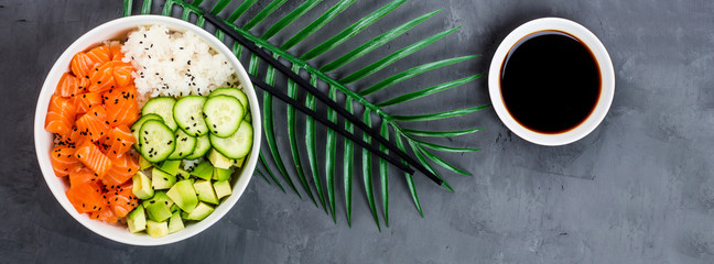 Hawaiian salmon bowl with cucumbers, avocado, sesame seeds and rice. Top view, overhead, flat lay, mock up, template. Healthy food concept