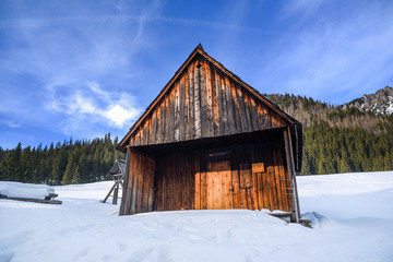 Little old wooden cabin in mountains in winter.