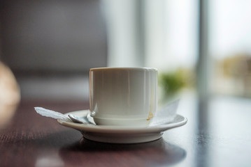 White cup from under coffee in a cafe. Photographed close-up.