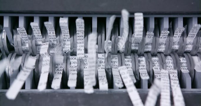 Sensitive document shredded through shredder close up of mechanical jaws