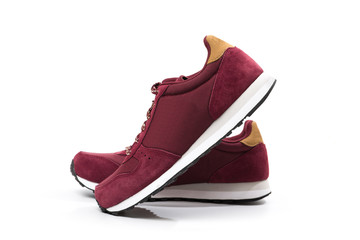 a pair of new burgundy, cherry sneakers or athletic shoes isolated on a white background.