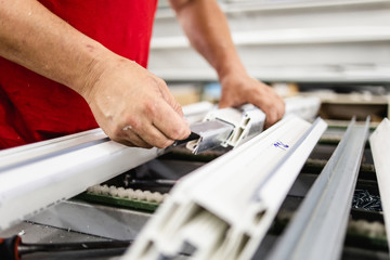 Manual worker assembling PVC doors and windows. Manufacturing jobs. Selective focus. Factory for aluminum and PVC windows and doors production.