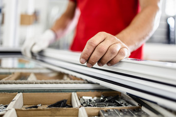Manual worker assembling PVC doors and windows. Manufacturing jobs. Selective focus. Factory for aluminum and PVC windows and doors production.