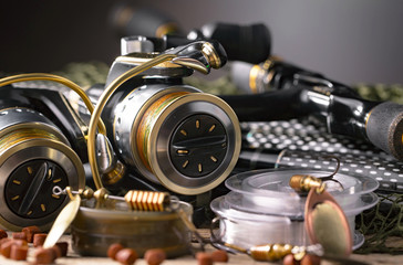 Plakat Fishing rods and spinnings in the composition with accessories for fishing on the old background on the table