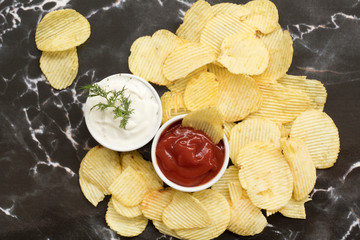 Potato chips dipped in sauce. Top view.