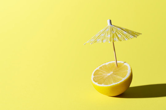 Lemon fruit and cocktail umbrella. Summer drink concept