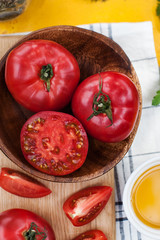 Ripe red and pink tomatoes whole and cut on a wooden Board. Food photo for ecomarket.