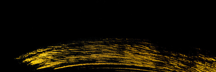 Golden stroke trace with acrylic paint by art brush on a black background.