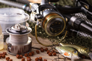 Fishing rods and spinnings in the composition with accessories for fishing on the old background on...