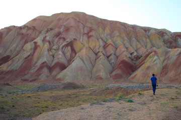 Tabriz, Iran - May 28, 2017: Stunning unusual colored mountains in Iran near Tabriz. Turis man on a background of mountains. Natural attractions of Iran.