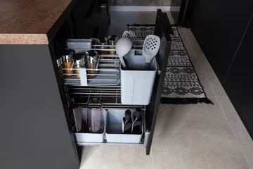 Kitchen storage solution. Pull out kitchen accessory for spice, bottles, kitchen spoons and even cutting boards.  © rois010