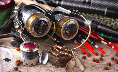Fishing rods and spinnings in the composition with accessories for fishing on the old background on...