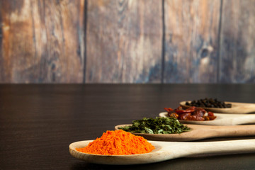 four wooden spoons in line with assorted spices