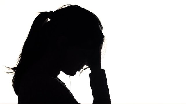 silhouette of a young upset woman holding forehead on his hands, girl in depression and thinks to solve problem,concept of emotional stress and life