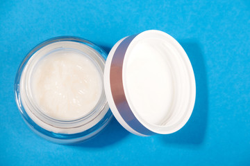 white cosmetic cream in a jar on a blue background