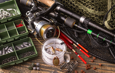 Fishing rods and spinnings in the composition with accessories for fishing on the old background on...