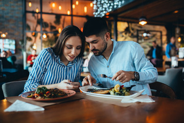 friends using mobile phone in restaurant