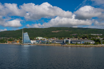 Naklejka premium Molde, Norway - july 2019. Modern architecture on the background of Scandinavian mountains and blue sky. Sunny day in Molde, Norway.