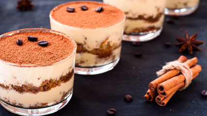 tiramisu in a glass decorated with coffee beans on a dark background