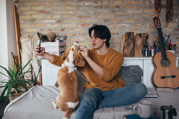 young man playing with his dog at home