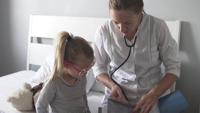 The doctor shows the little girl a picture of her lungs after her pneumonia was cured and will tell the child what it is. 