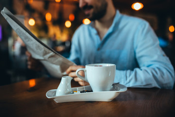 young man reading newspapers in cafeteria