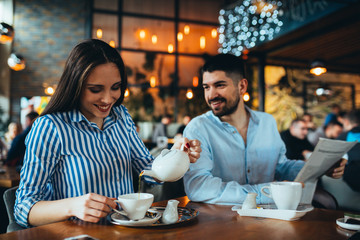 romantic couple drinking tea in cafeteria