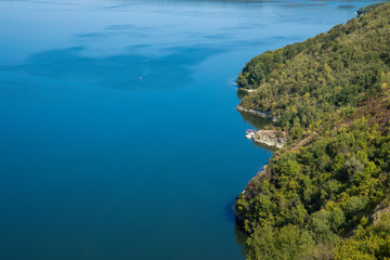 top view aerial landscape sea side forest edge waterfront coast line blue water surface and green foliage scenery from above in summer time with copy space for your text here