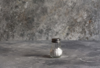 Salt in a glass jar on a concrete background. Salt shaker.