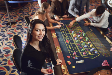 Happy smiling girl smiling at the roulette in a casino