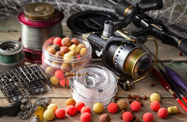 Fishing rods and spinnings in the composition with accessories for fishing on the old background on the table