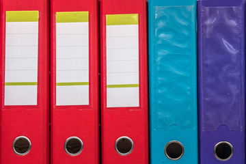 row of folders for papers and documentation on a shelf in the office