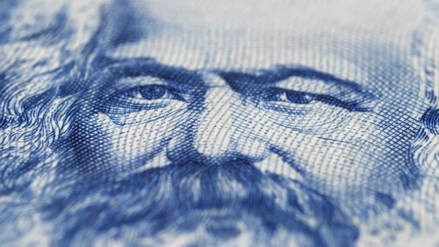 Karl Marx on East German banknote macro rotated. Philosopher, economist, sociologist, socialist. Founder of marxism and communism. Low angle. 4K, 422 10 bit