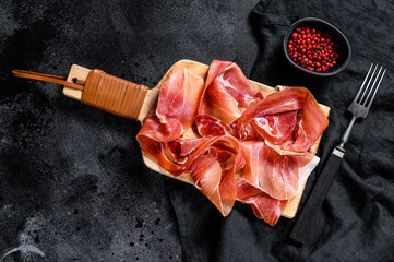 Spanish jamon Serrano, ham. Black background, top view, space for text