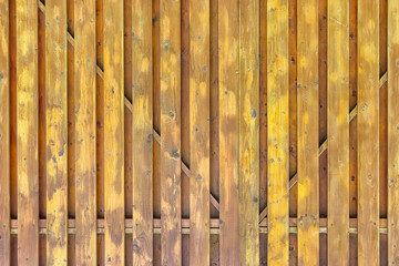 A fragment of a painted wooden gate. The structure of the boards and battens. Dirty yellow surround background for layouts.