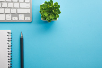 Blue desk office with laptop, smartphone and other work supplies with cup of coffee. Top view with...