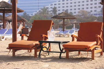 Beach landscape. Deck chairs on the sand in Dubai.