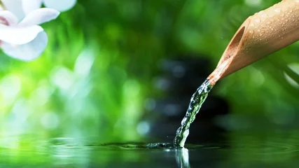 Een stroom water die uit een bamboebuis stroomt © Jag_cz