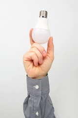 Male hand holds an electric lamp on a white background