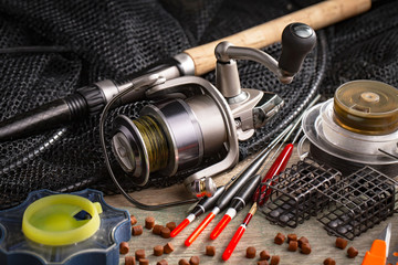 Fishing rods and spinnings in the composition with accessories for fishing on the old background on...