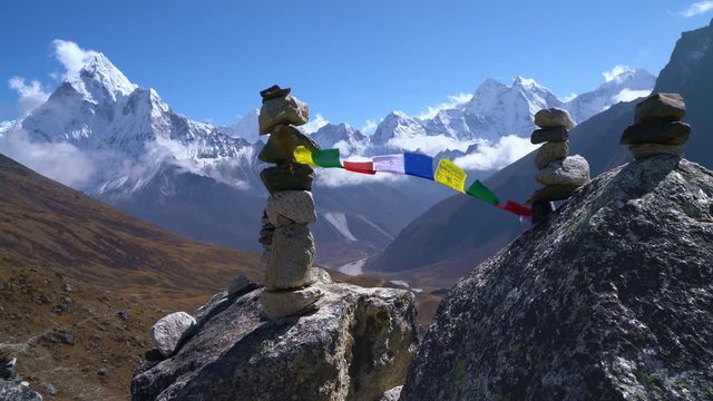 Holy buddhist praying multicolored flags with mantras flapping and waving on the  strong wind with valley view and Ama Dablam 6812m peak.Everest Base Camp trekking route near Dughla 4620m.  