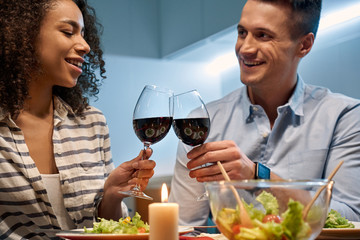 Young adult man and african american woman enjoying romantic dinner at home