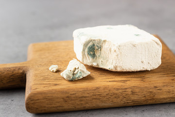 Live or real baking yeast block with fungus (mold) on a wooden cutting board.