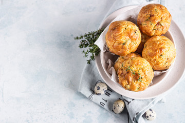 Savory muffins with bacon, quail egg, green onion and cheese on a light stone background. Protein breakfast. Paleo or keto diet.