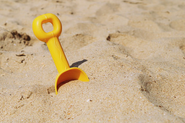 Fototapeta na wymiar Plastic children's sand scoop on the beach