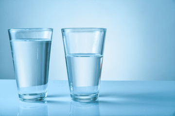 Glasses of fresh water on color background