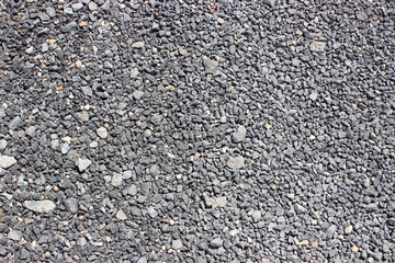 Crushed old asphalt pavement. Small gray-black pebbles.
